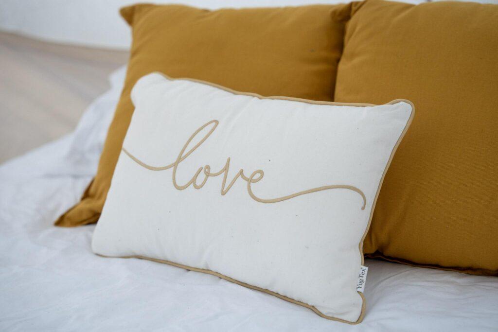 A white decorative pillow with the word 